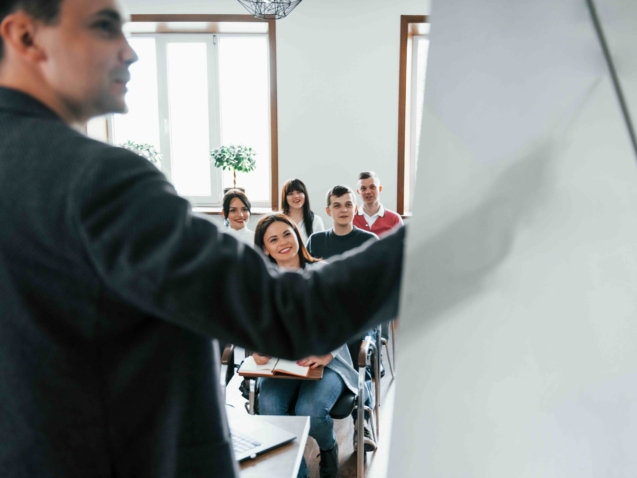 Showing data. Group of people at business conference in modern classroom at daytime.